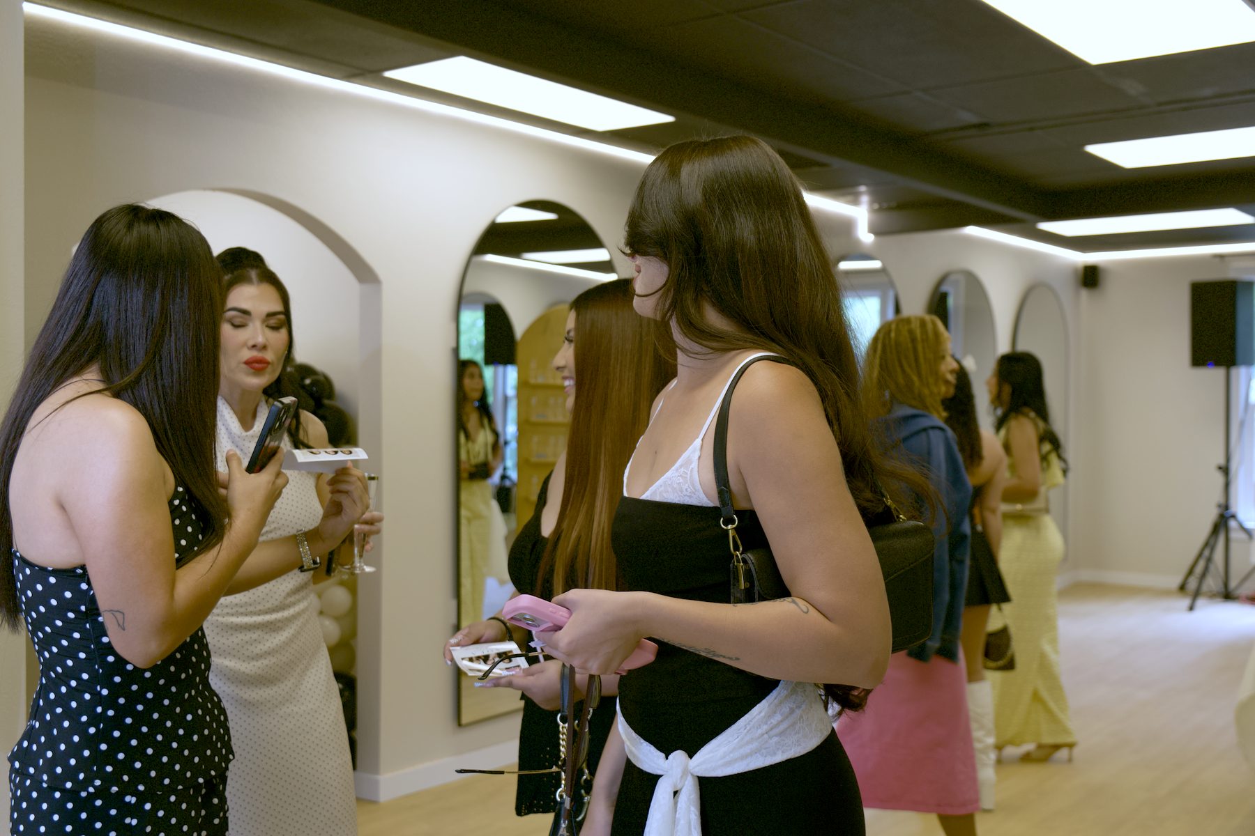 Guests holding photo prints and chatting at an event